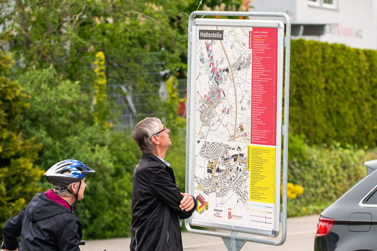 Besucher studieren den Situationsplan an der Haltestelle